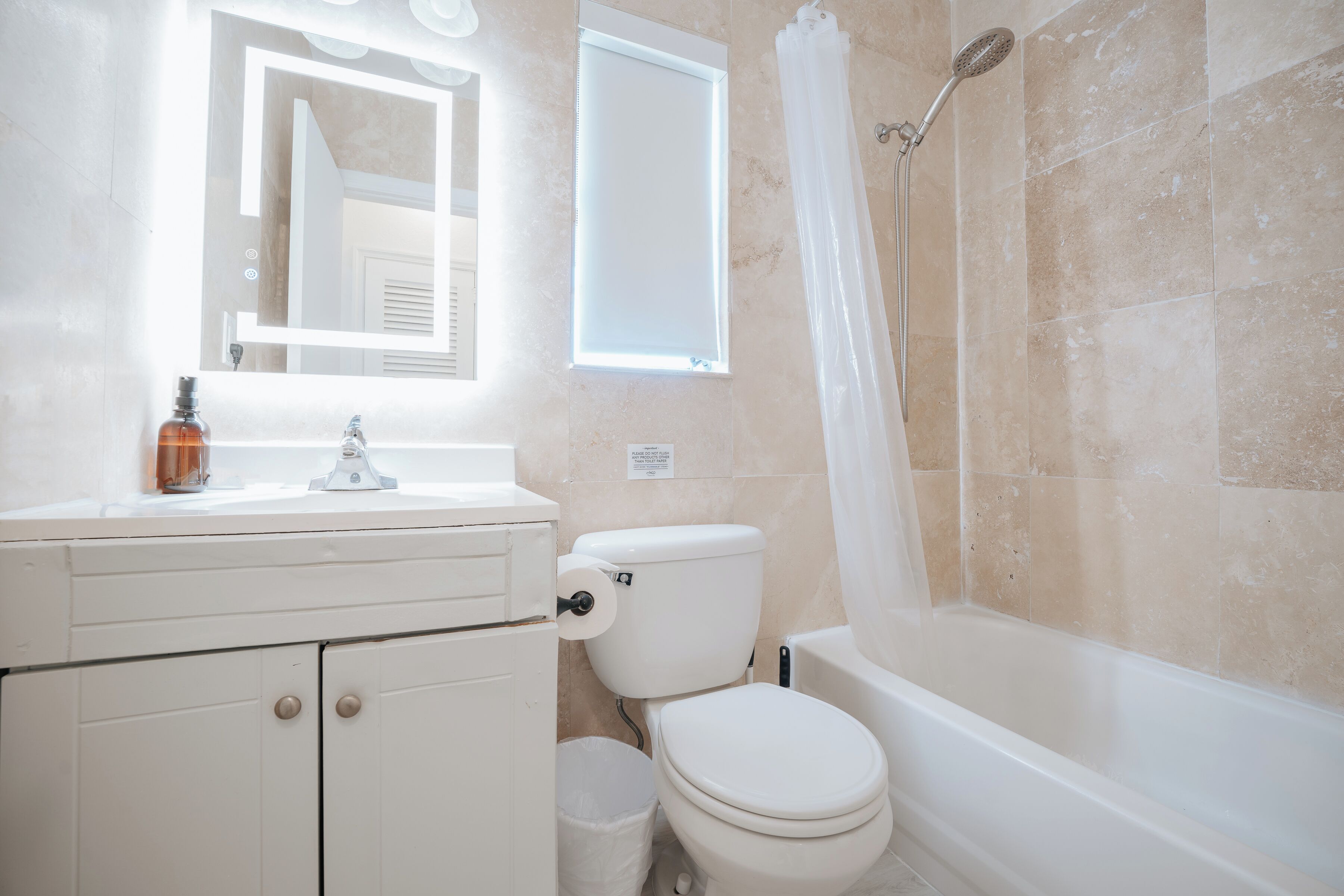 A bathroom with a toilet, sink, and bathtub.