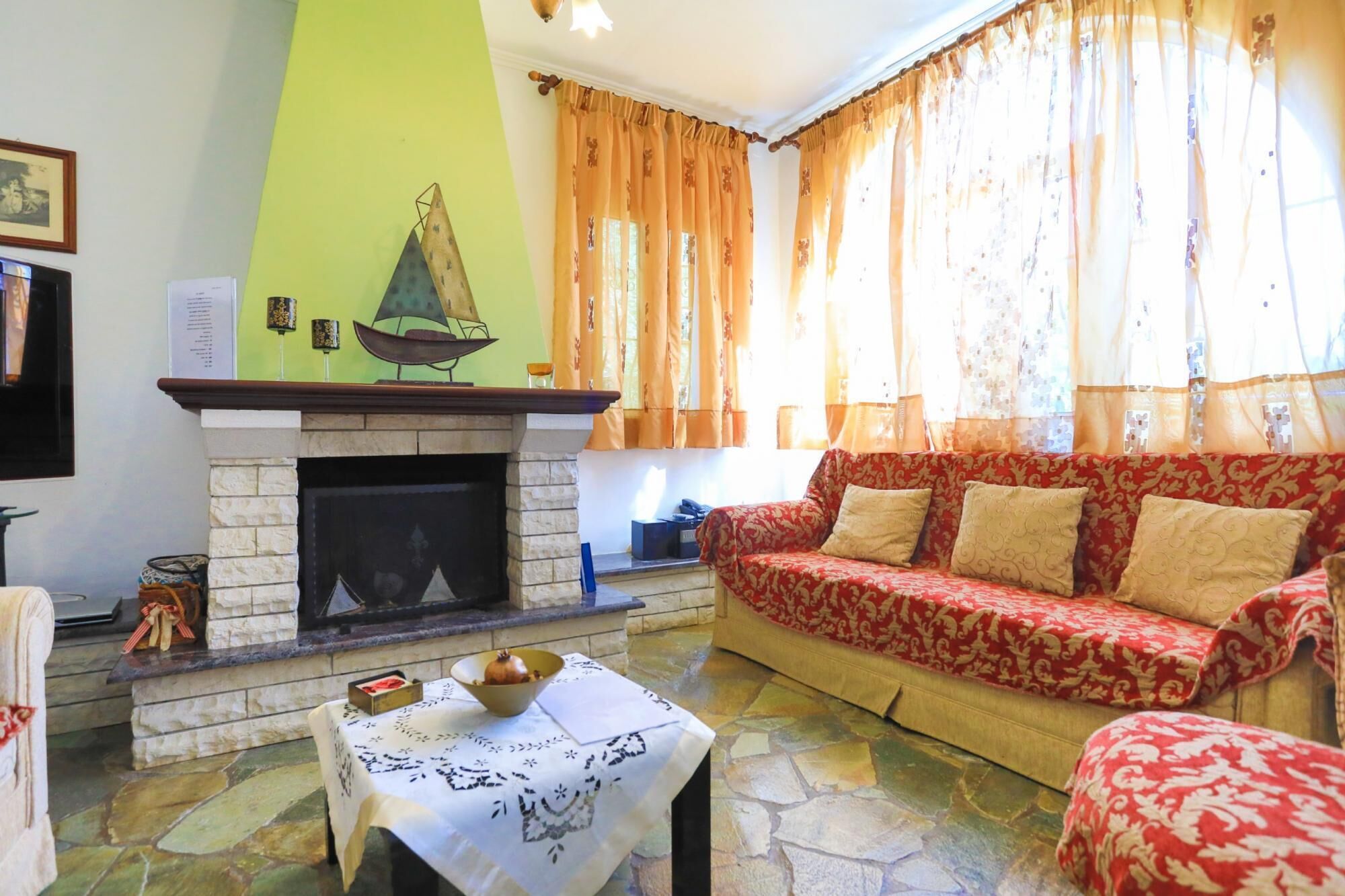 Una sala de estar con chimenea, un sofá y una mesa con un mantel individual.