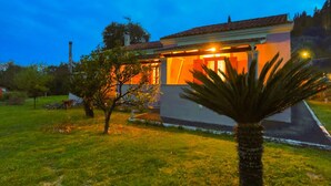Uma casa de dois andares com uma varanda visível e um gramado bem cuidado.