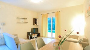 A modern living room with a dining area, a television, and a cabinet. - Villa Anamari in (Corfu)