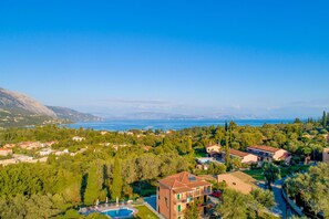 A coastal residential area with houses, a swimming pool, and a view of the sea.