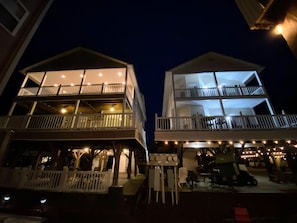 A two-story building with balconies, outdoor seating, and a covered area with tables and chairs. - 4 bed/4Baths 2 mins. to ocean on golf cart -Free Waterpark with your stay! (Myrtle Beach)