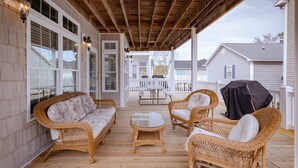 A covered porch with wicker furniture, a table, and a grill. - 4 bed/4Baths 2 mins. to ocean on golf cart -Free Waterpark with your stay! (Myrtle Beach)