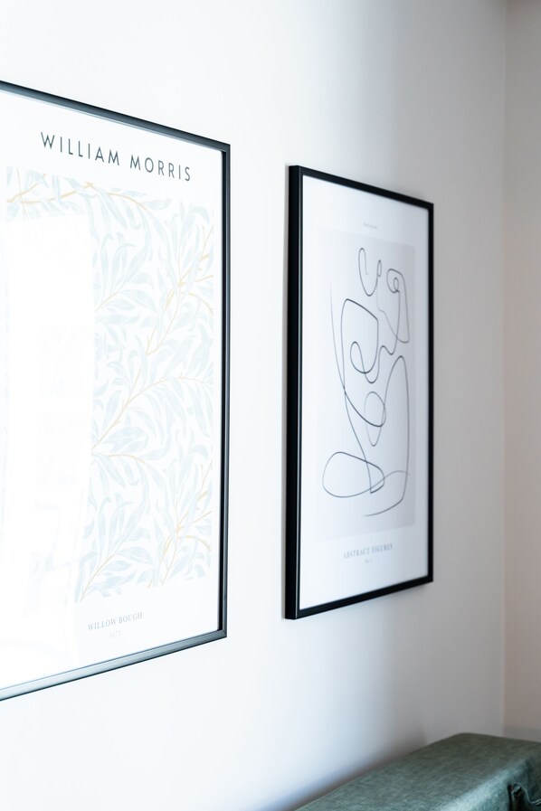 Two framed artworks on a wall, one titled "William Morris" and the other "Abstract Figure." - Empress Luxury Residences (Volos)