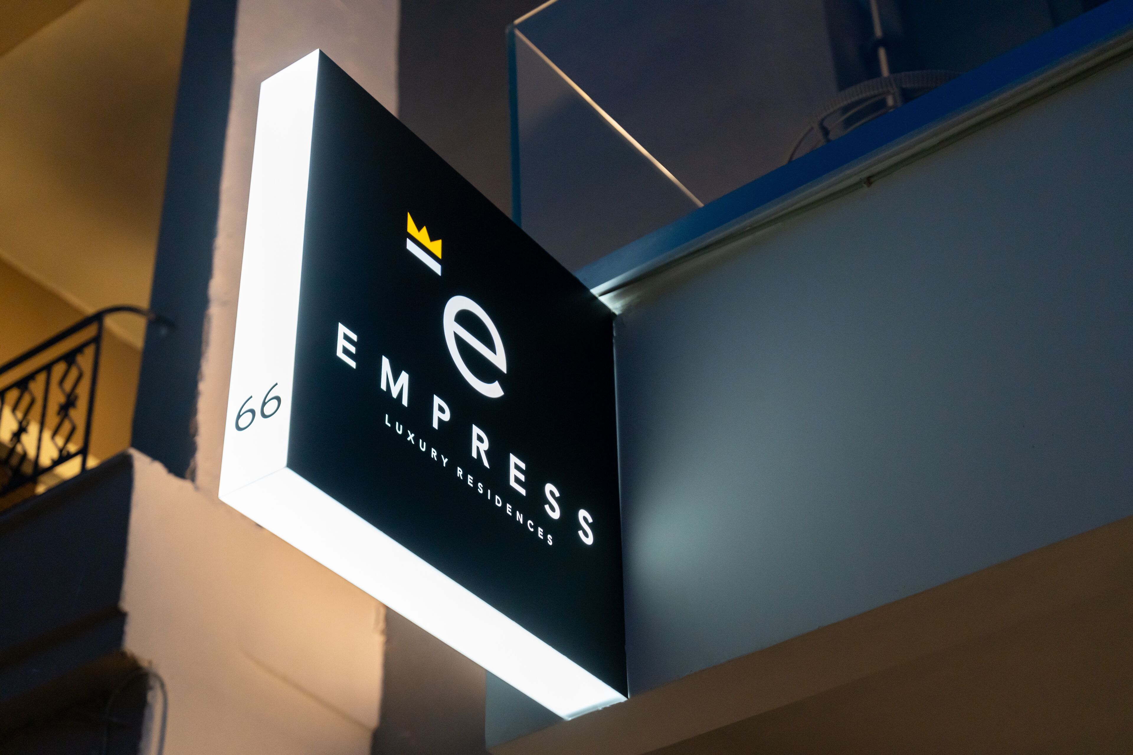A sign for 'EMPRESS Luxury Residences' with a crown symbol and the number 66.