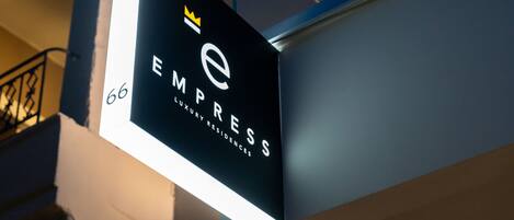 A sign for 'EMPRESS Luxury Residences' with a crown symbol and the number 66.