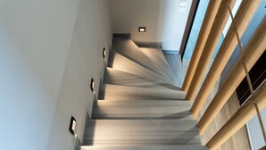 Una escalera moderna con barandillas de madera e iluminación empotrada.