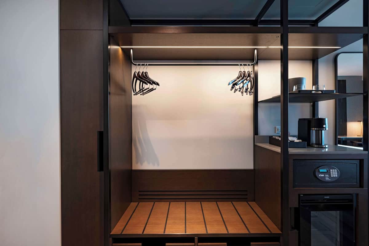 A compact, modern kitchenette with a built-in coffee maker, a microwave, and a small refrigerator.
