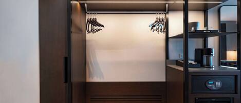 A compact, modern kitchenette with a built-in coffee maker, a microwave, and a small refrigerator.