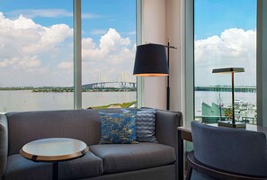 A modern room with a large window offering a view of a bridge and water. - Hyatt Regency Baytown-Houston (Baytown)