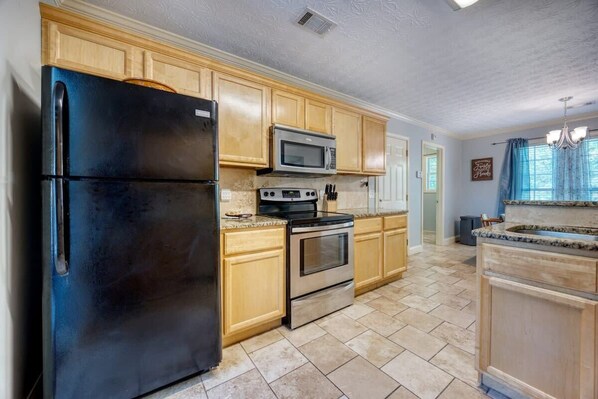 Enjoy cooking in this well-equipped kitchen with a refrigerator, microwave, and oven.