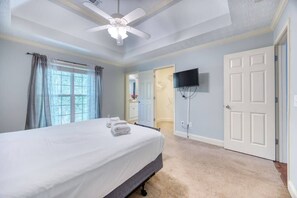 Relax in a spacious room with a large bed, ceiling fan, and flat-screen TV.