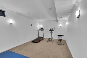 A gym with a treadmill, elliptical, and stationary bike.