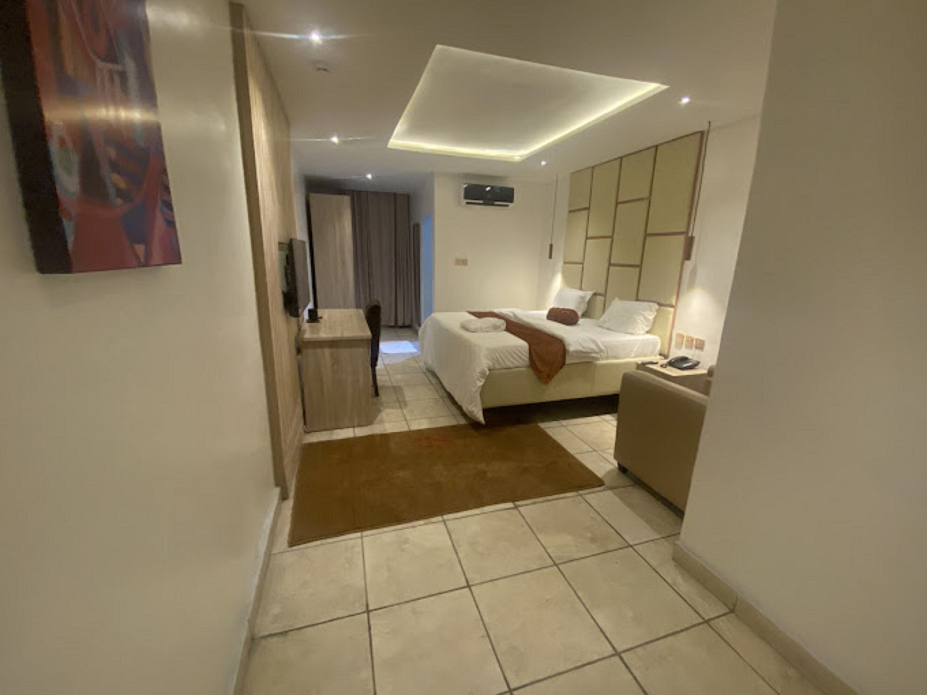 Et moderne hotelværelse med en stor seng, et skrivebord og et opholdsområde.