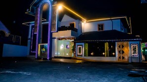 A hotel with a modern design, featuring a prominent neon-lit entrance and a well-lit facade. - Hopeland Hotels (Port Harcourt)
