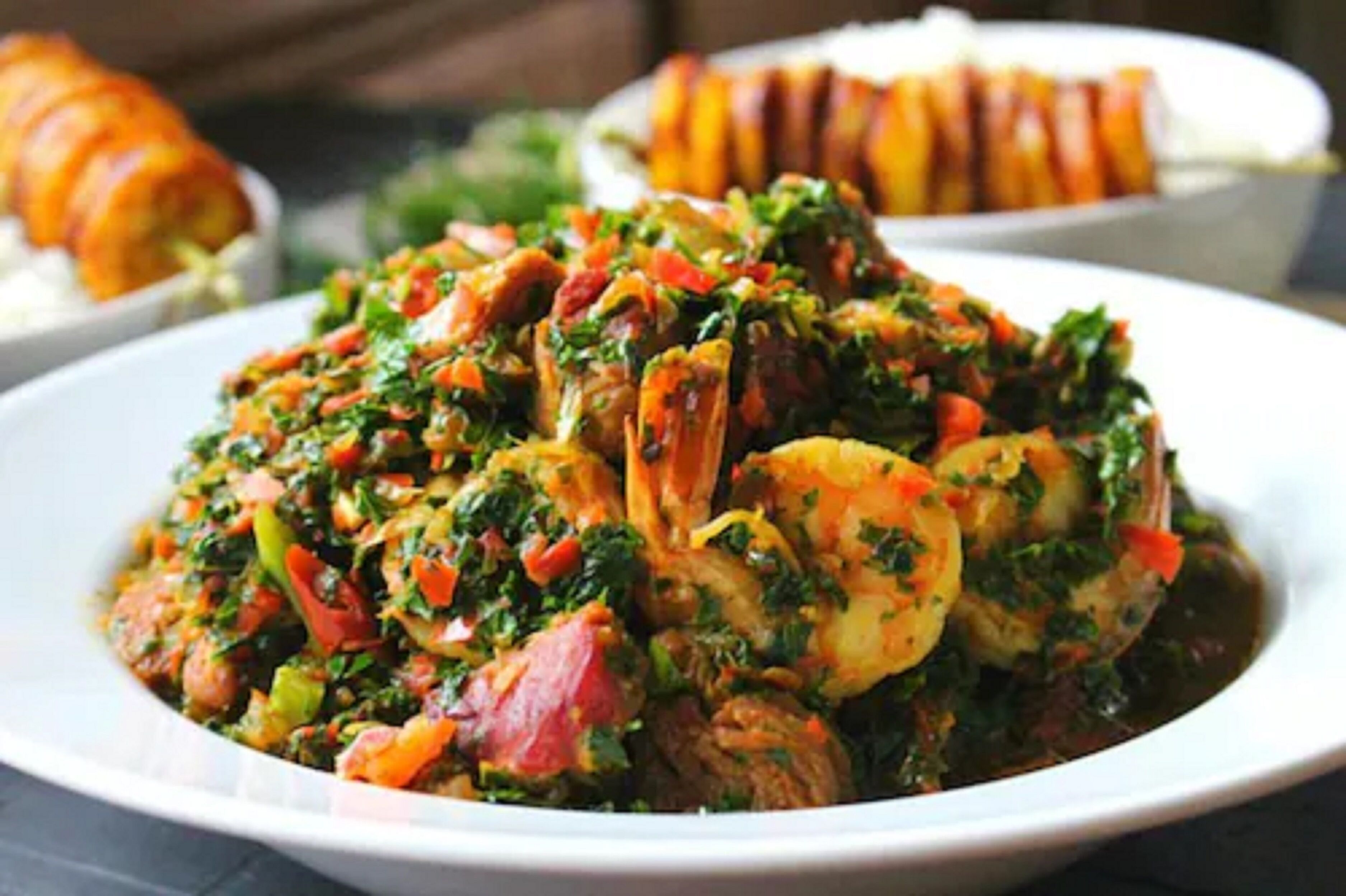 A dish of shrimp and vegetables in a white bowl.