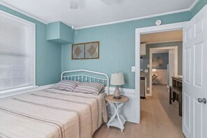 Cozy retreat with a single bed, round table, and lamp, set against light blue walls.