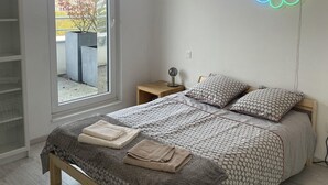 A bedroom with a bed, pillows, a bedside table, a lamp, and a window. - Exceptional apartment in Strasbourg (Strasbourg)