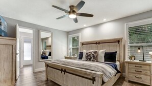 A bedroom with a bed, bedside tables, a ceiling fan, and a window with blinds. - Waterfront, Heated Pool, Dive In Theater,Family Friendly (Cape Coral)