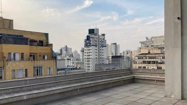 Una terraza en la azotea con vistas a un paisaje urbano.