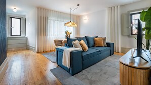 Un salon moderne avec un canapé bleu, une table basse et un meuble pour la télévision.