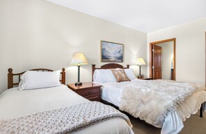A hotel room with two beds, a wooden headboard, a painting on the wall, and a mirror on the door. - FRONT ROW Ski-In Ski-Out Updated 2BR Slopeside with Gondola, Slope & Base VIEWS! (Winter Park)