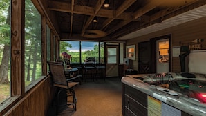A wooden interior with a kitchen area, a dining table with chairs, and large windows offering a view of the outdoors. - Lakefront Home | Private Dock, Hot Tub & Kayaks (Murray)