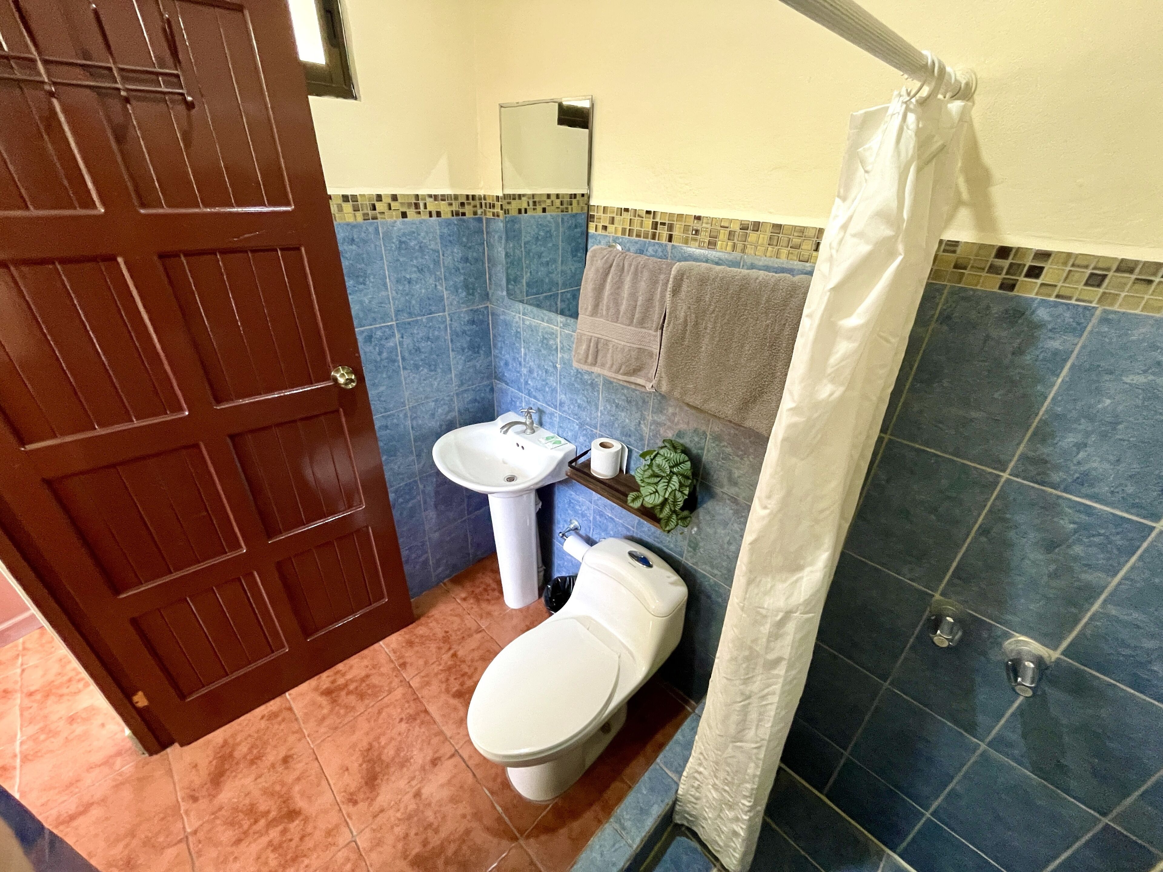 Ein Badezimmer mit Toilette, Waschbecken und Duschvorhang.
