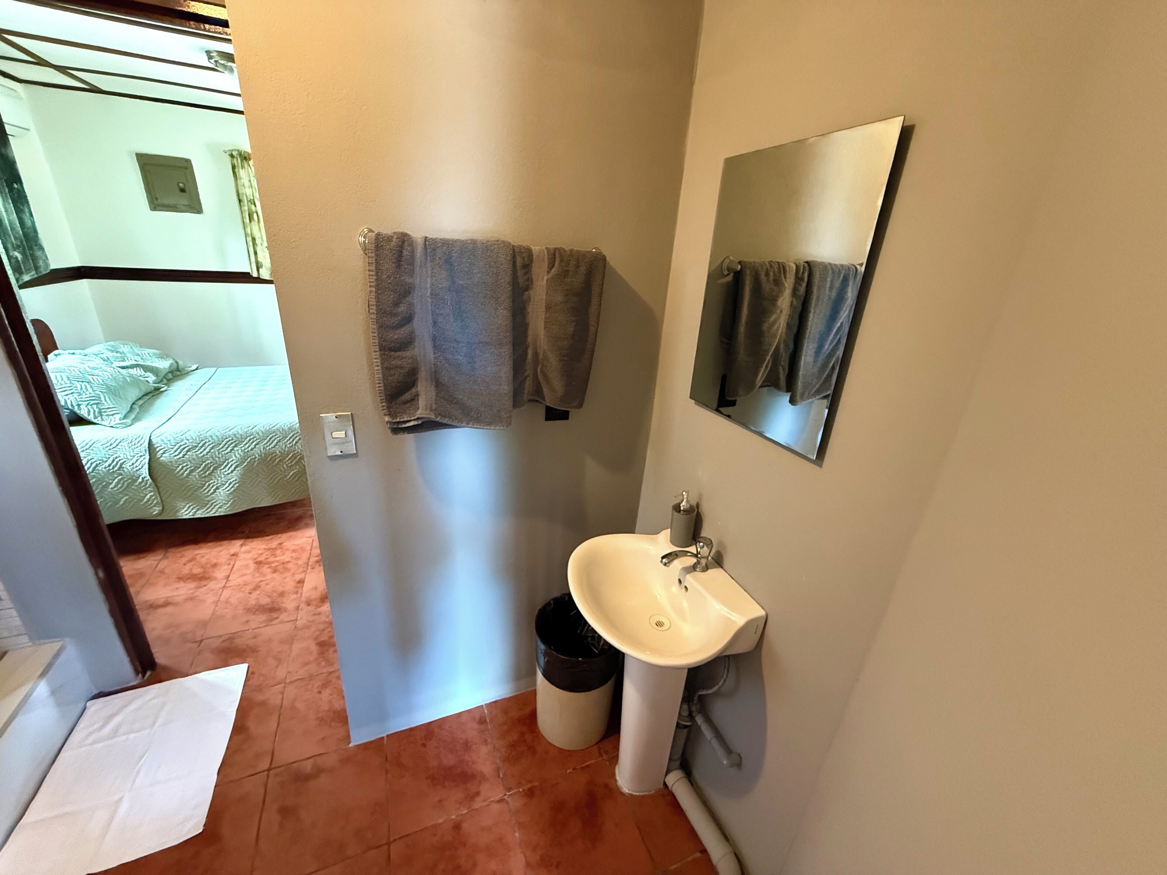 A bathroom with a sink, mirror, and two towels hanging on the wall.