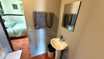 Ein Badezimmer mit Waschbecken, Spiegel und zwei Handtüchern an der Wand.