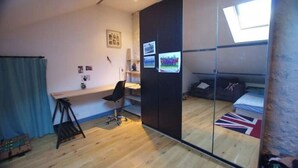 Una habitación pequeña con escritorio, silla y cama decorada con una bandera del Reino Unido.