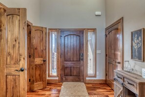 A wooden door with a glass panel, a wooden bench, and a small table with a basket. - Mimosa Fields: Designer Kitchen w/ Outdoor Oasis (Fruita)