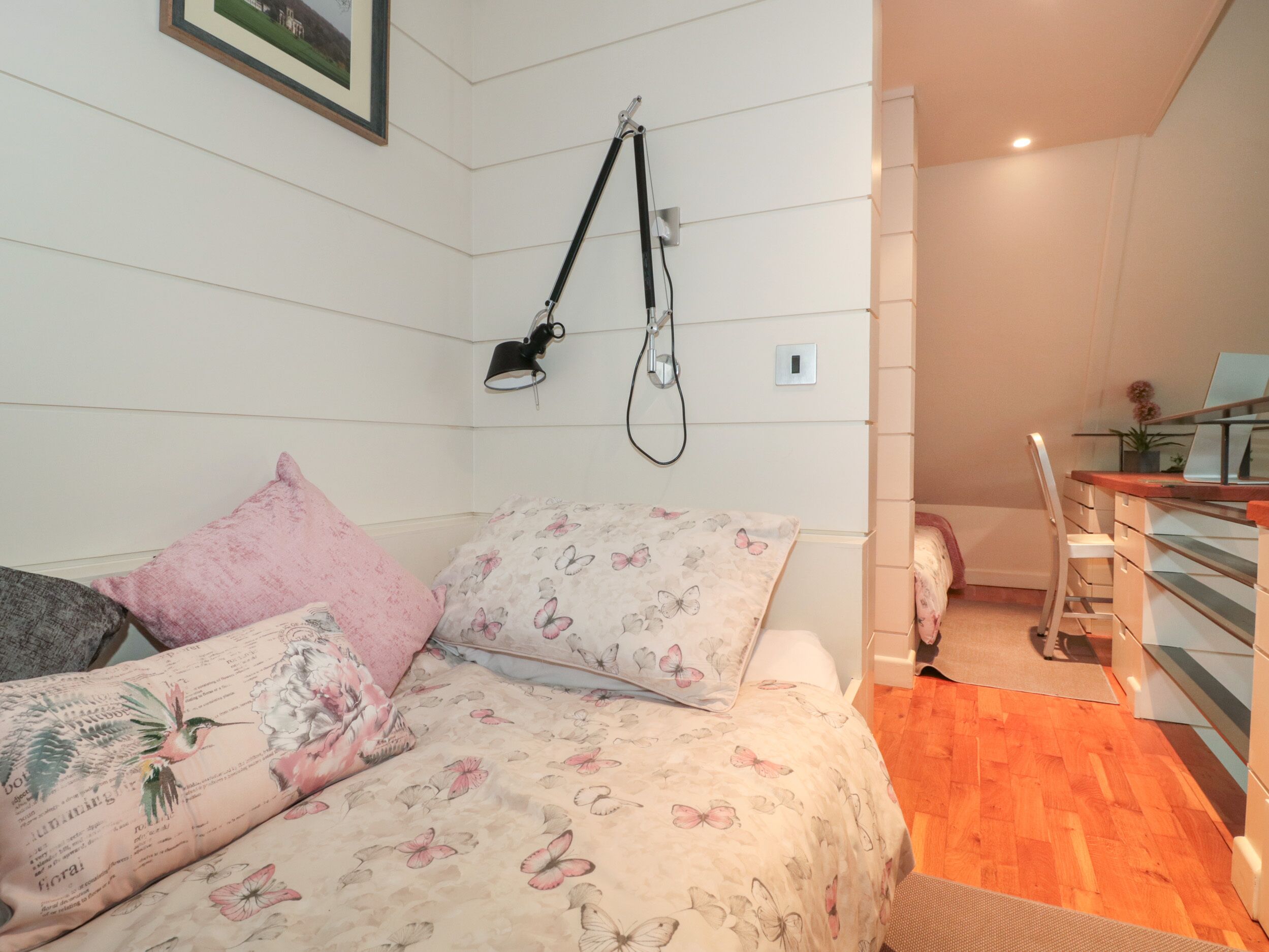 A bedroom with a bed, a desk, and a chair.