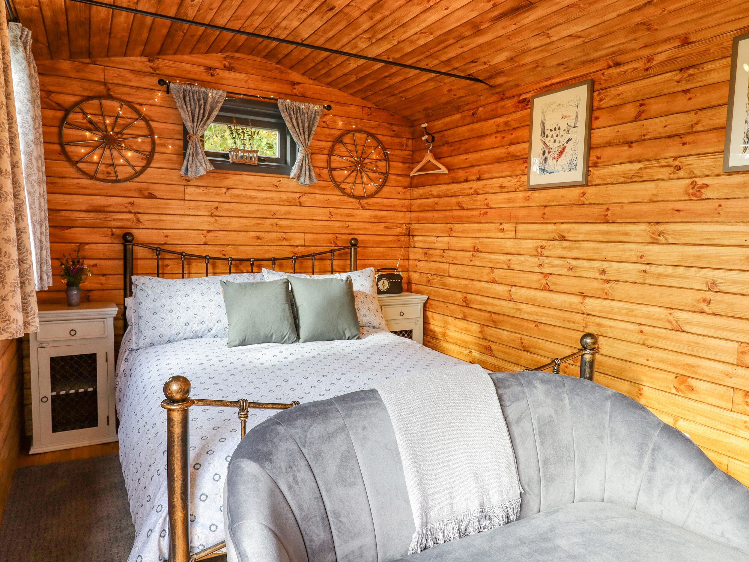 A cozy wooden cabin bedroom with a bed, bedside table, and a chair.