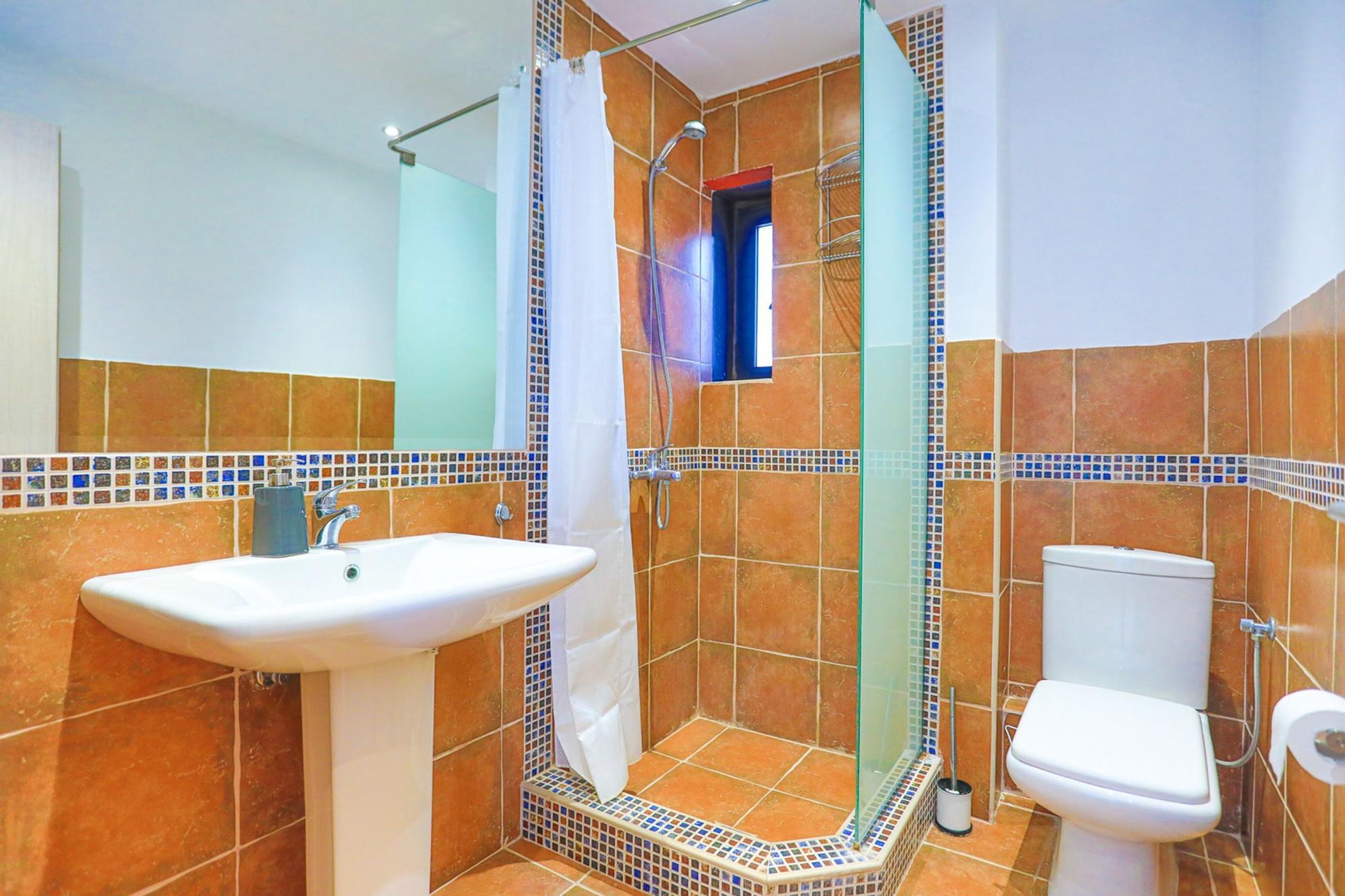 Un baño con ducha, lavabo e inodoro.