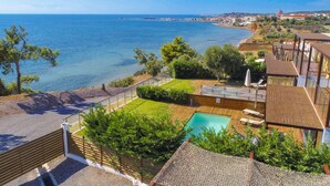 A coastal property with a swimming pool, wooden deck, and a view of the sea. - Kalma Villa Ena in Moudania (Nea Propontida)