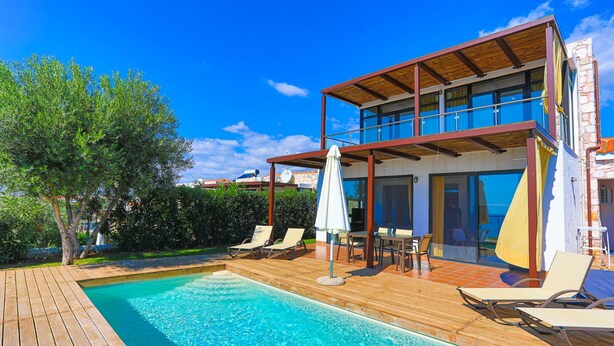 A modern two-story house with a swimming pool, outdoor furniture, and a wooden deck. - Kalma Villa Ena in Moudania (Nea Propontida)