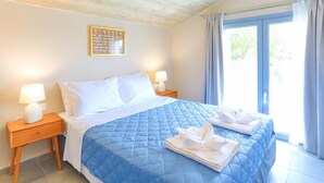 Hotellihuone, jossa on sänky, kaksi yöpöytää, ikkuna verhoilla ja seinäkoriste.