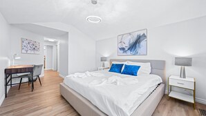 Una camera da letto moderna con un letto grande, comodini, una scrivania e una sedia.