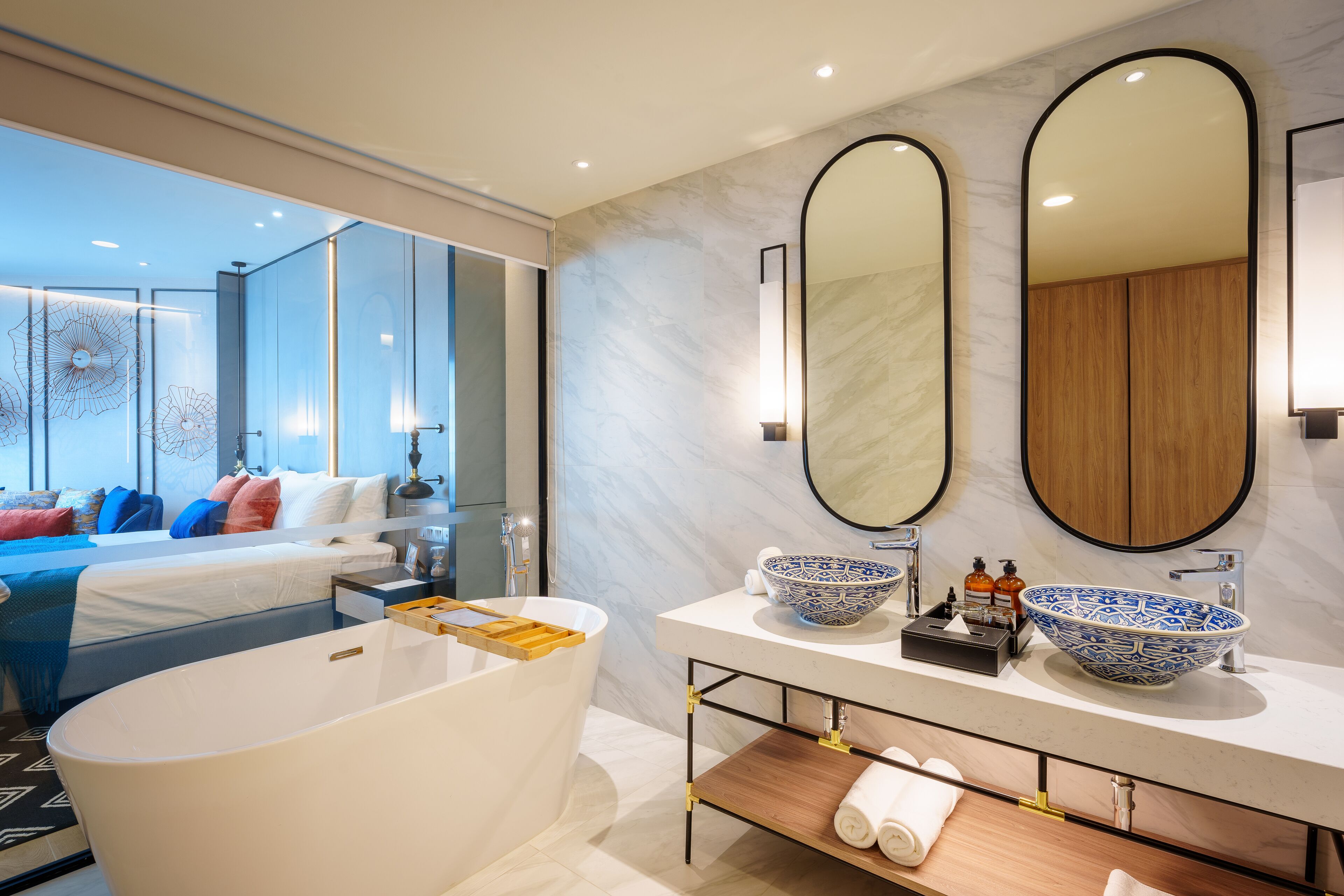 A modern bathroom with a freestanding bathtub, two vessel sinks, and a large mirror.