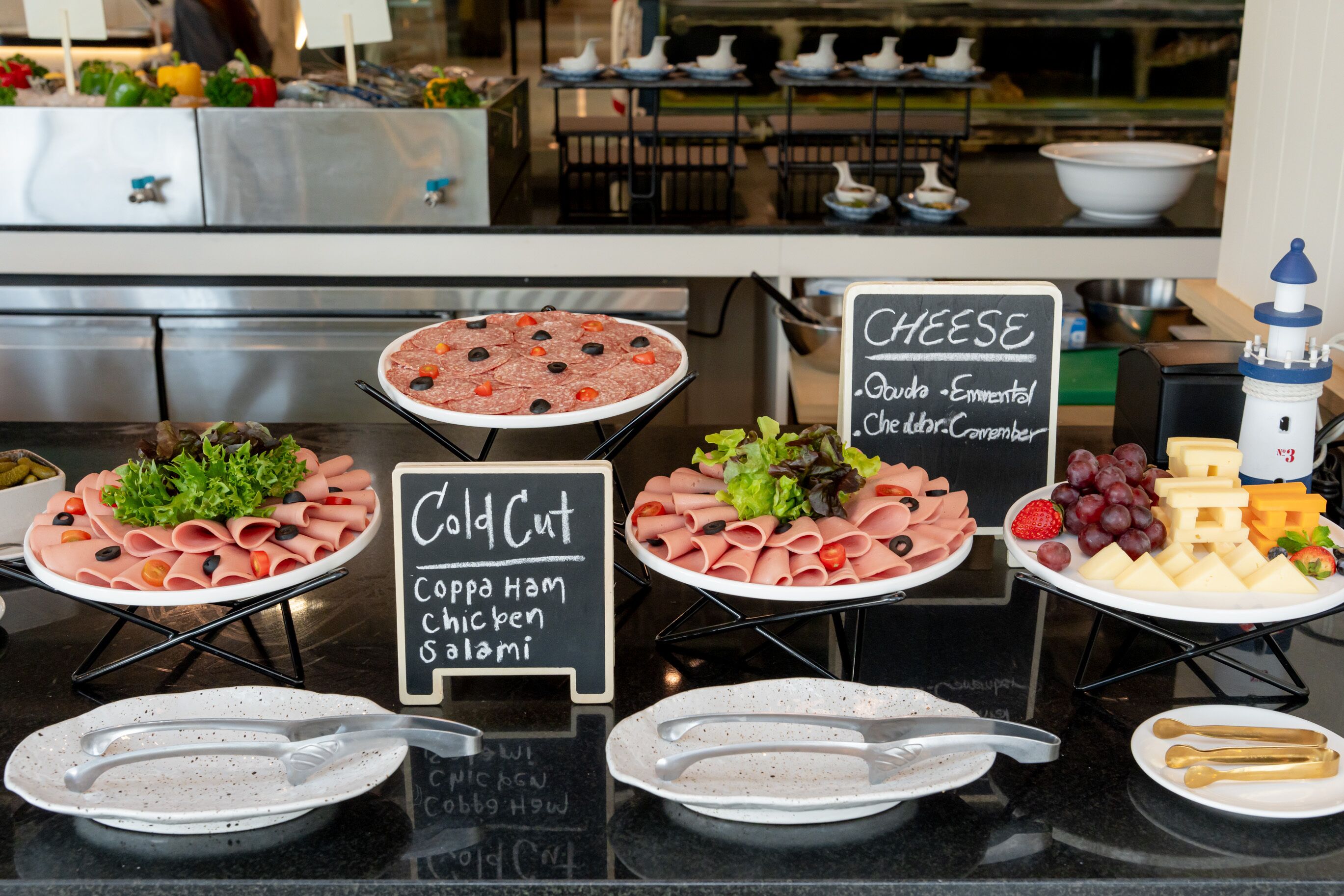 A buffet with cold cuts, cheese, and a sign indicating the availability of coffee, ham, chicken, and salami.