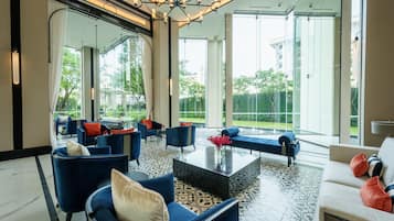 Un espacio habitable amplio con muebles modernos, ventanas grandes y vistas a zonas verdes.