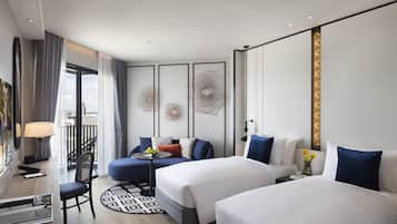 Una habitación de hotel moderna con dos camas, un escritorio y un balcón.