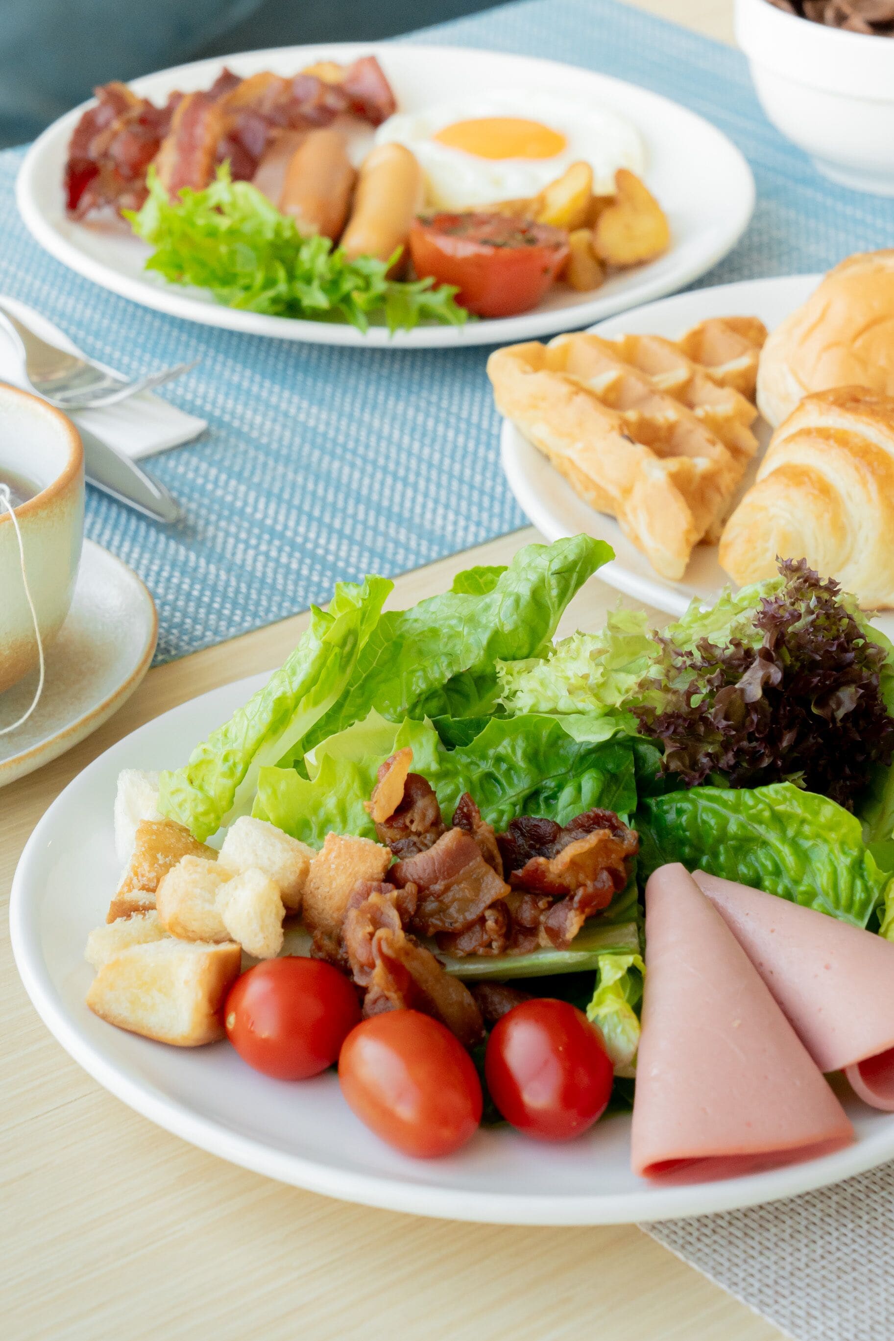 A breakfast setting with plates of eggs, bacon, and toast.