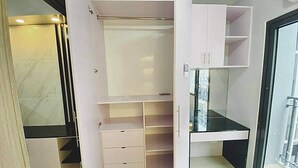 A modern interior with a built-in closet, a glass door leading to a balcony, and a black countertop.
