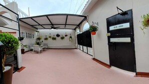 Uma área externa coberta com assentos e plantas em vasos.