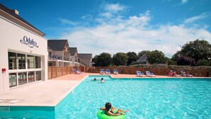 A swimming pool area with a building labeled "Odaly's" and a person on a green float.