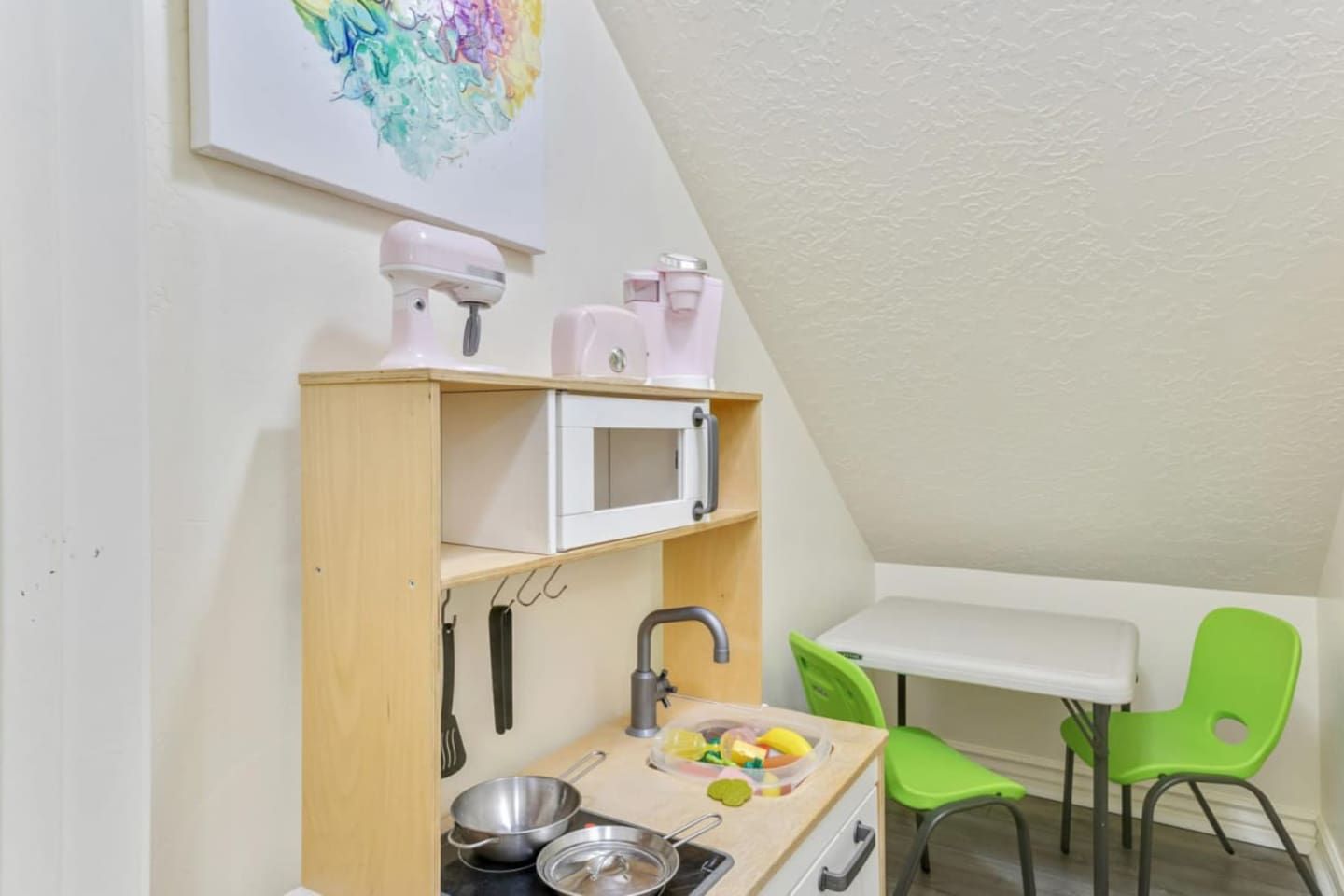 Toy closet with a play kitchen under the stairs