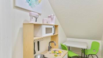 Toy closet with a play kitchen under the stairs