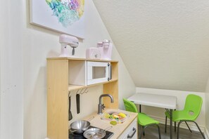 Toy closet with a play kitchen under the stairs - The Gathering Place for Paws, Friends, and Family (Orem)